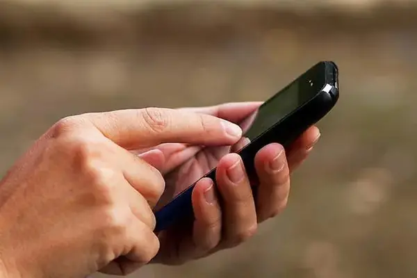 Person håller i en telefon.