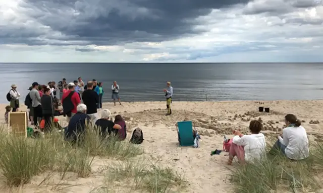 Presentation about life environments on the beach, standing on a sand model of Kristianstad.