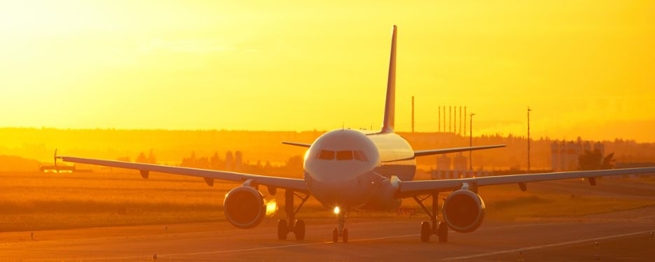 Ett flygplan på landningsbanan i soluppgång.